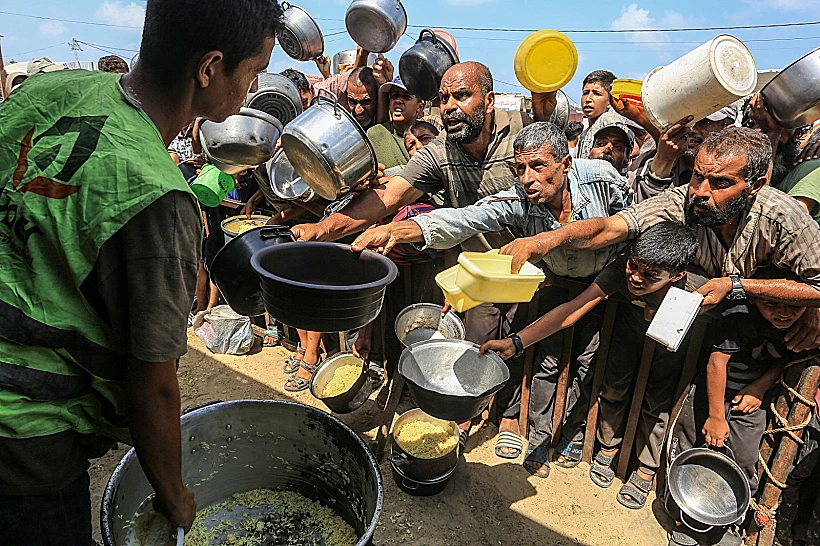 פלסטינים בתור לקבלת מזון בח'אן יונס, דרום רצועת עזה