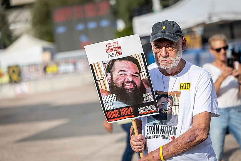 איציק הורן בכיכר החטופים עם תמונת בנו איתן