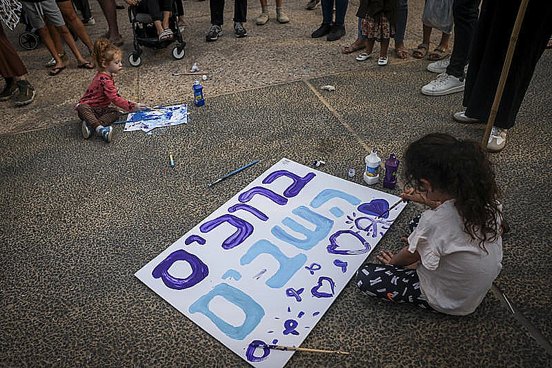 ילדים מכינים שלטים בכיכר החטופים