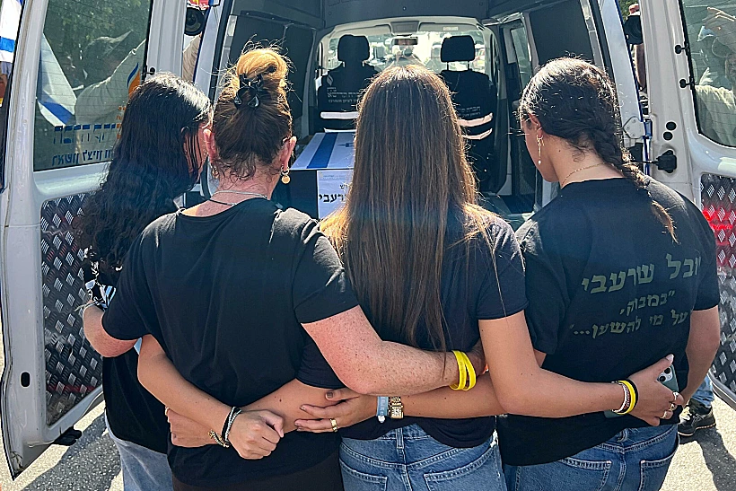 בנות משפחת שרעבי צועדות מאחורי הארון של החלל יוסי שרעבי במסע הלווייתו לבארי