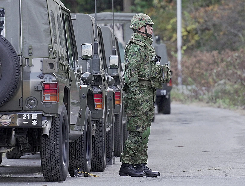 A Member Of Japan Self Defense Forces (jsdf) Stands Next To Military Vehicles During A Practice Setting Up A Bear Trap In Kazuno