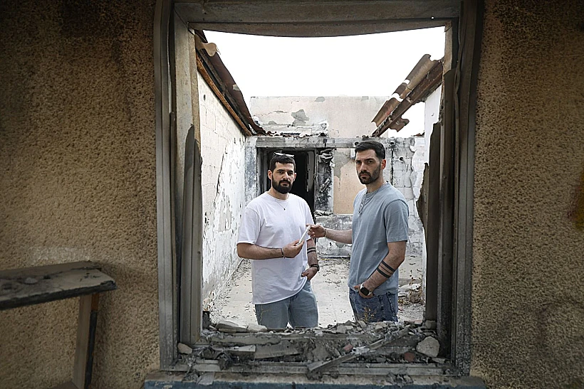 גלי וזיו ברמן בכפר עזה עם המזוזה ששרדה את הטבח