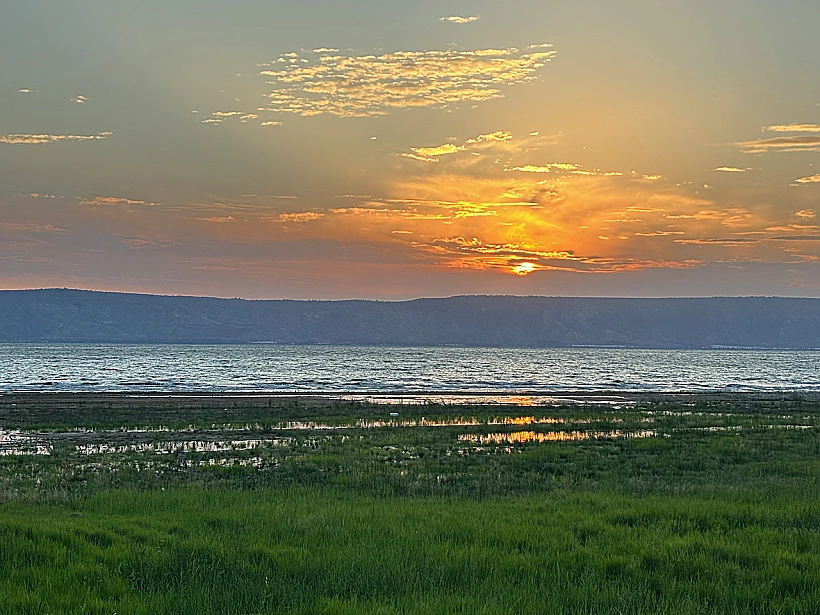 זריחה על שפת הכנרת, מול הרי גולן במלון מגדלה