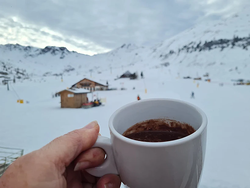 כוס שוקו סמיך וחם על רקע שלג באיטליה