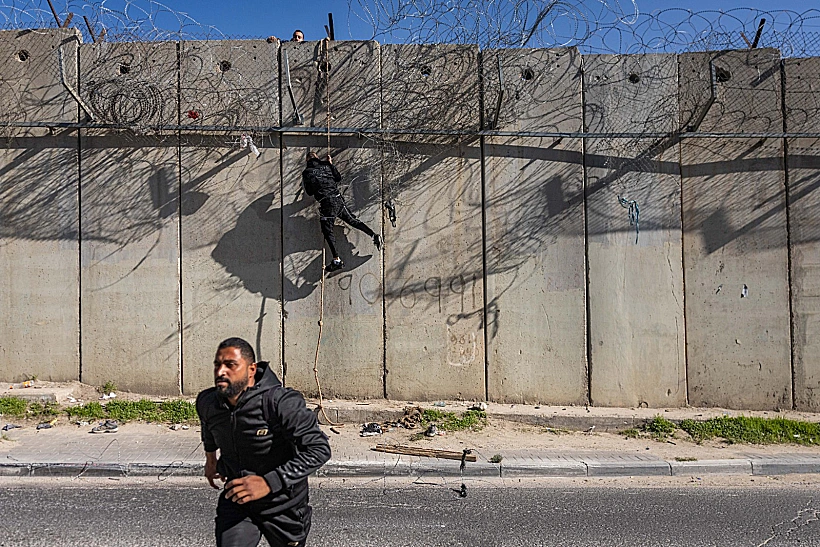 שוהים בלתי-חוקיים פלסטינים חוצים את גדר ההפרדה בעוטף ירושלים באמצעות חבל