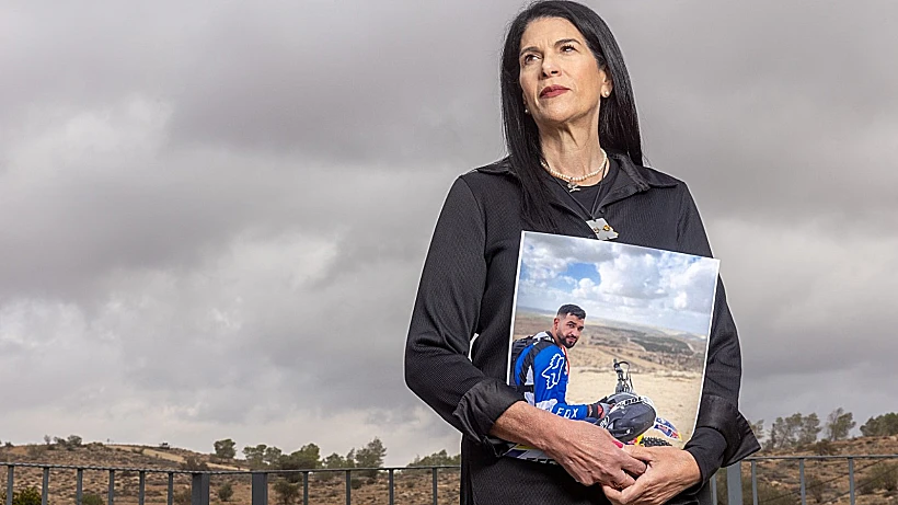 טליק גואילי עם תמונת בנה רן, החטוף האחרון בעזה