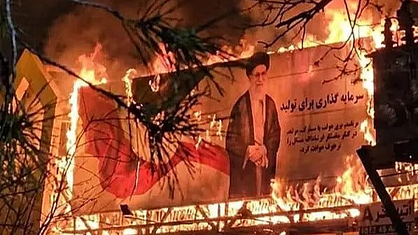 שלט עם תמונת חמינאי עולה בלהבות