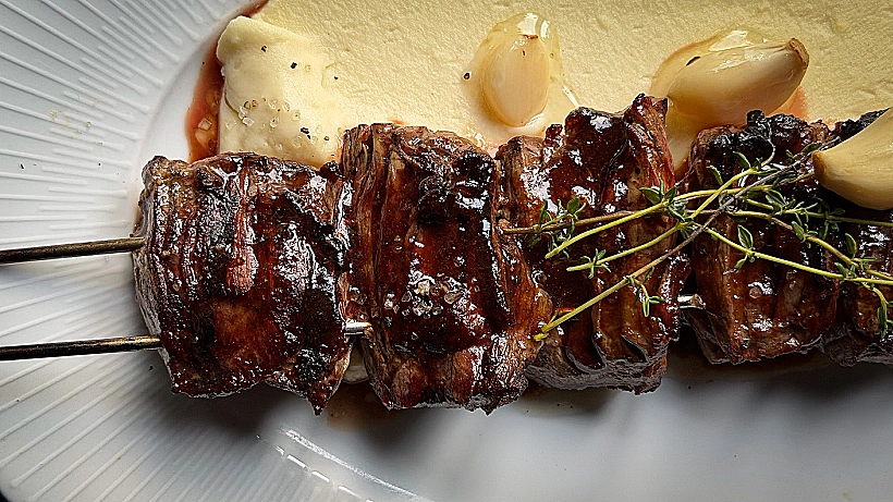 שיפוד נתח קצבים על מצע של גראטן תפוחי אדמה