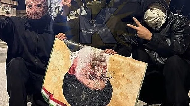 מפגינים נגד המשטר באיראן עם תמונת חמינאי