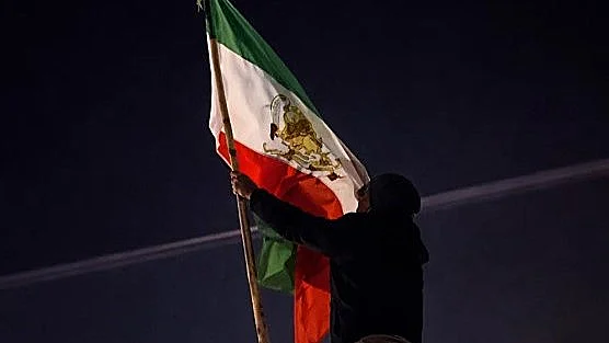 מפגין באיראן מניף את דגל השאה