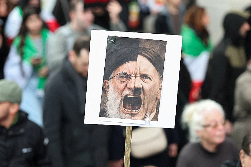 שלט בהפגנה בלונדון המשווה בין חמינאי להיטלר