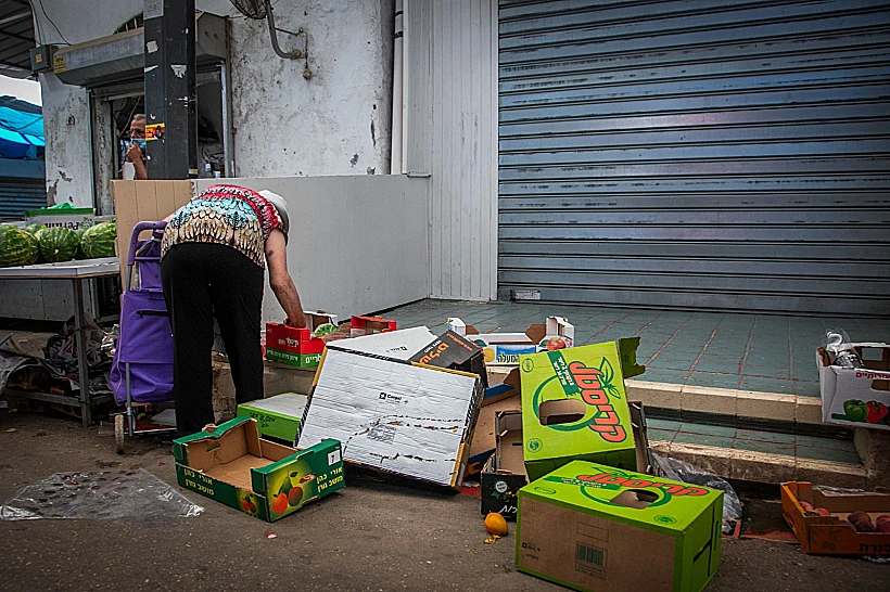 אישה מחפשת מזון בשוק רמלה