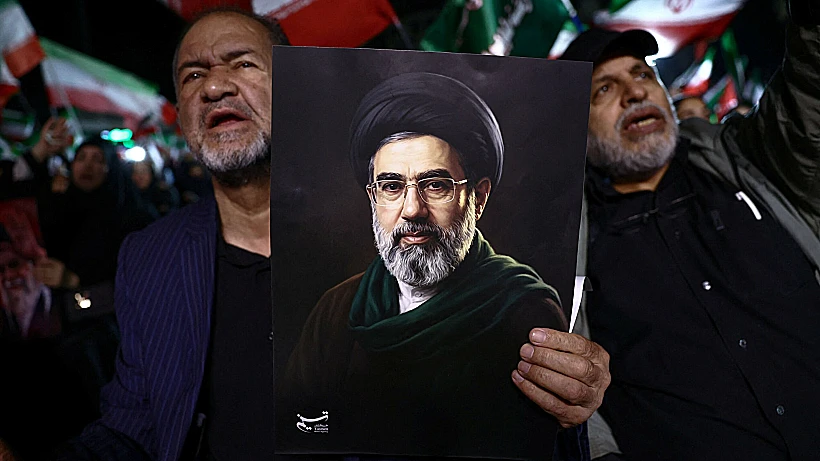 אזרחים בטהרן אוחזים בתמונתו של מוג'תבא חמינאי