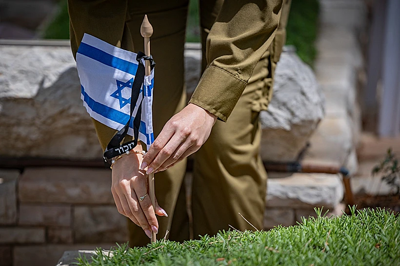 חיילת מניחה דגלי ישראל על קברי חללי צה"ל בהר הרצל