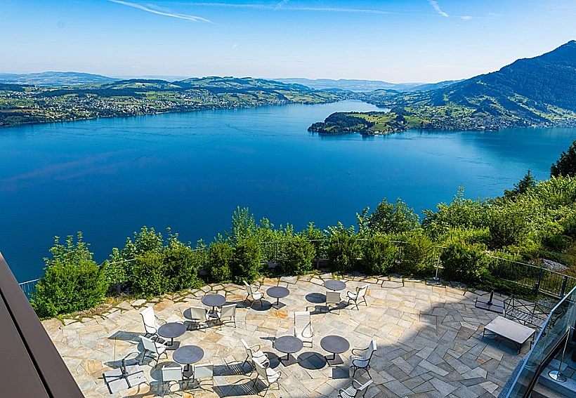 Outdoor,terrace,of,swiss,burgenstock,resort,,switzerl נוף של אתר הנופש Bürgenstock Resort בשוויץ and,,with,chairs,and