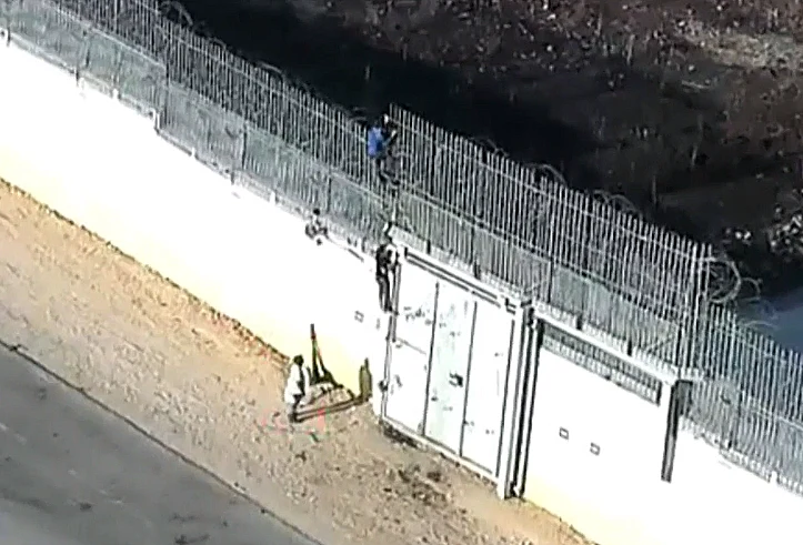 פלסטינים מטפסים על הגדר