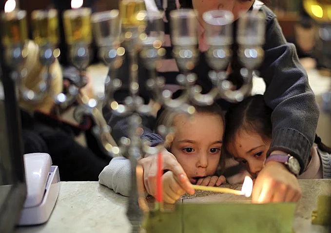 ילדים מדליקים חנוכיה