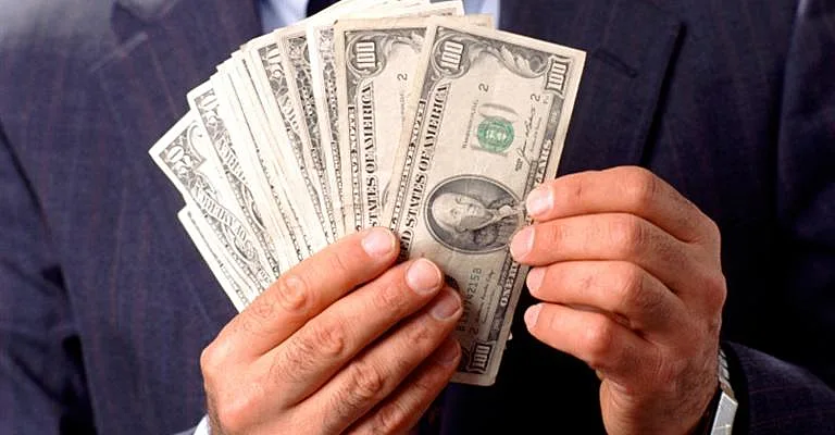 אדם מחזיק שטרות של 100 דולר