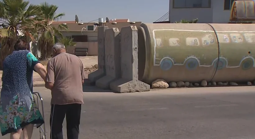 בני הזוג יורי ולובה תושבי שיכוני העץ בדרכם לסוללת המגן שהוצבה בשכונתם