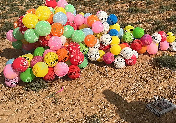 מטען מחובר לצרור בלונים גדול בקיבוץ צאלים