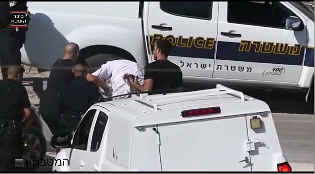 שוטר מושך בפאות של גבר חרדי