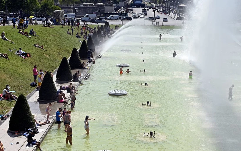 אנשים מתקררים במזרקות טרוקדרו ליד מגדל אייפל במהלך גל החום בפריז