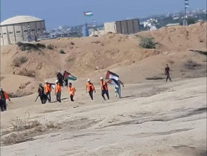 סדרני חמאס בווסטים כתומים בדרך לגדר