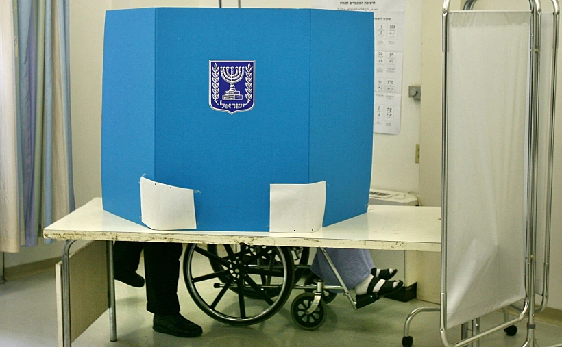 אישה מצביעה בקלפי נגיש