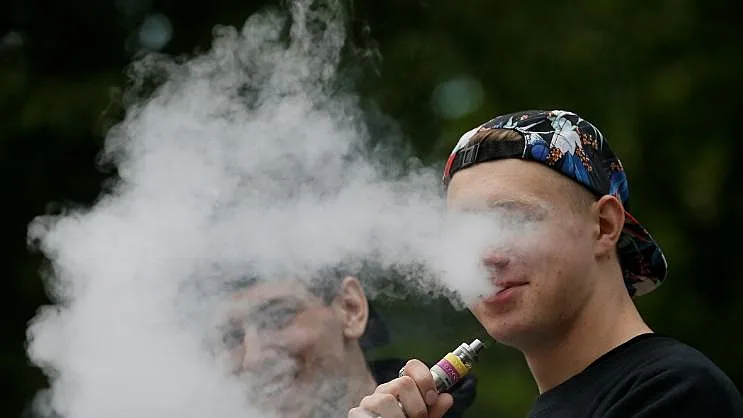 צעיר מעשן סיגריה אלקטרונית