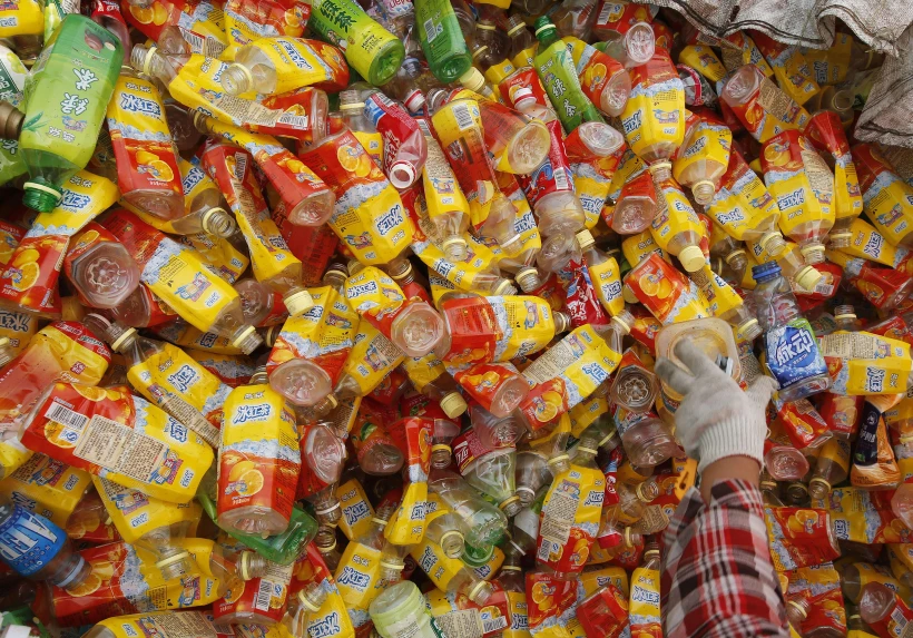 פועלת במפעל מיחזור בבייג'ינג מרימה בקבוק פלסטיק