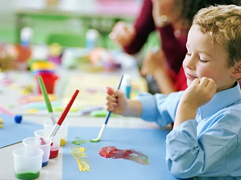 ילד מצייר עם צבע גואש בגן