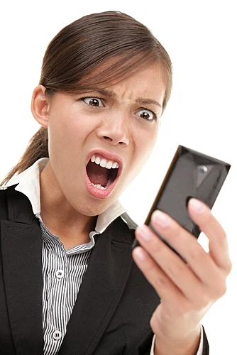 אישה מביטה במסך הנייד ונגעלת