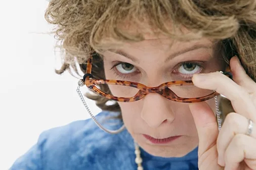 אישה מסתכלת מעל המשקפיים