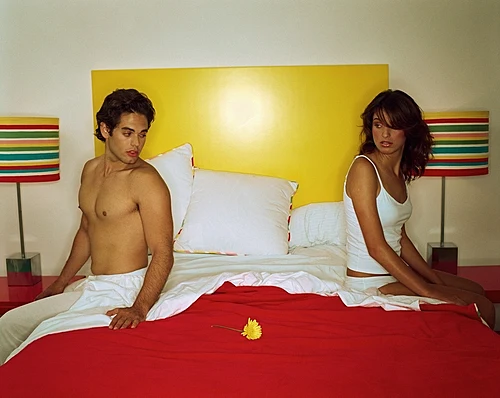 זוג יושב על מיטה, מרוחק אחד מהשני