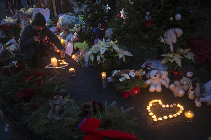 אישה באנדרטה לזכר הילדים שנרצחו בבית הספר סנדי הוק