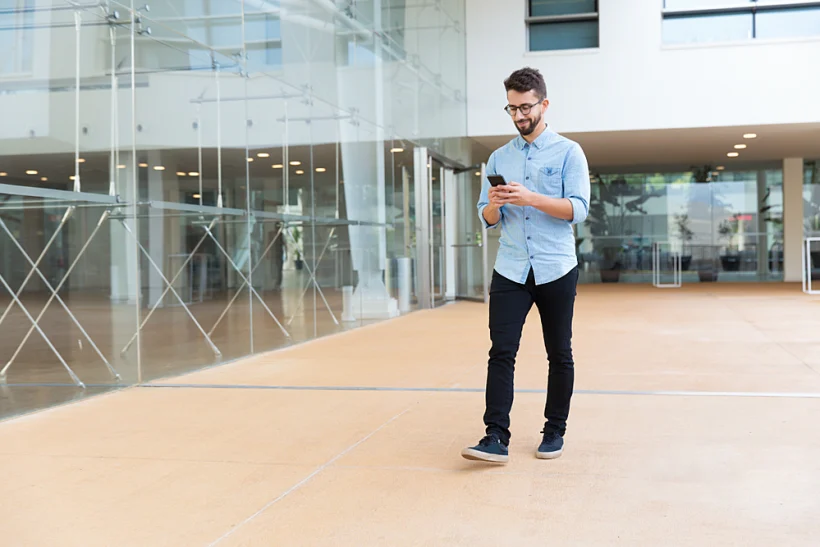 אדם הולך ברחוב עם סמארטפון