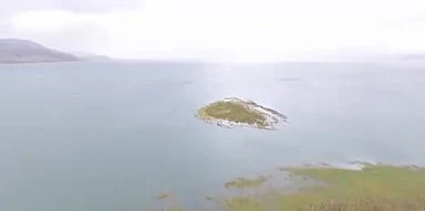 אי הולך ונעלם מול קיבוץ מעגן שלחוף הכינרת