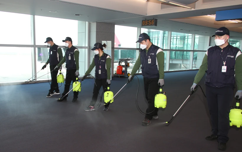 עובדי נמל תעופה בסין מחטאים את הרצפה משאריות של הנגיף הקטלני במדינה