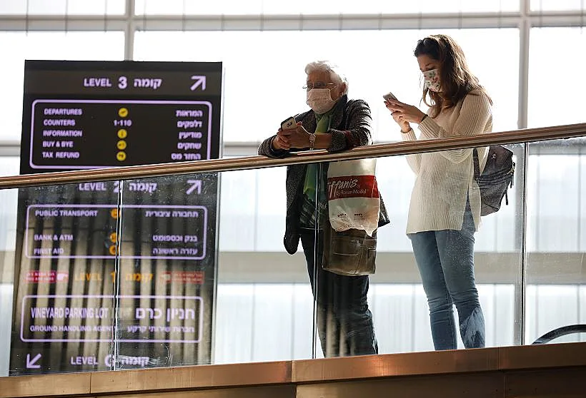 נוסעים בנתב''ג שעוטים מסכות כהגנה מפני הדבקה בקורונה