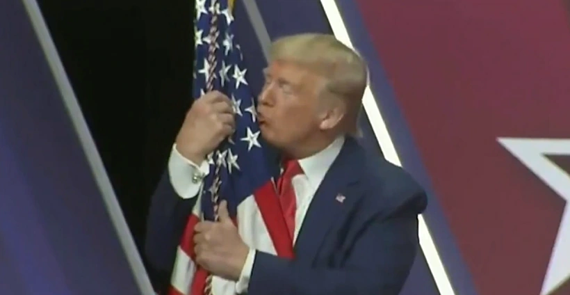 נשיא ארצות הברית דונלד טראמפ מנשק את דגל המדינה