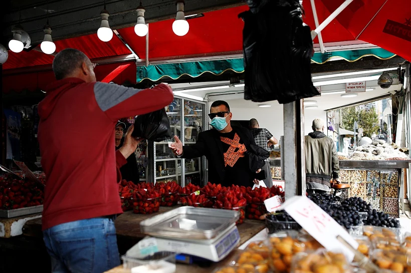 אדם הלובש מסיכת פנים בשוק בתל אביב