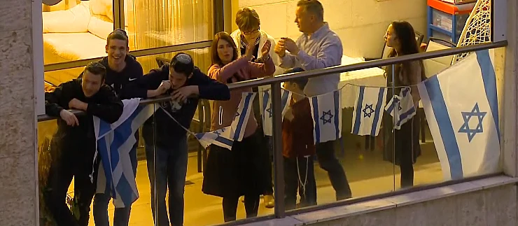 משפחה במרפסת ביתם בפתח תקווה מוחאת כפיים לצוותי הרפואה
