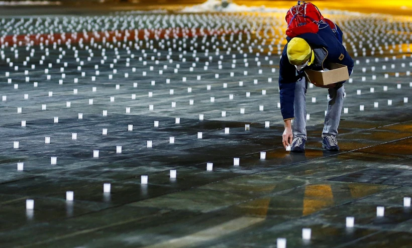 אזרח שווייצרי מדליק נר עבור קורבנות הקורונה