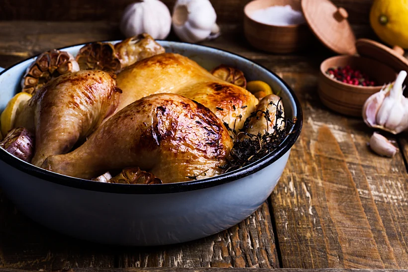 Roast,chicken,with,garlic,,thyme,and,lemon,in,cooking,pan