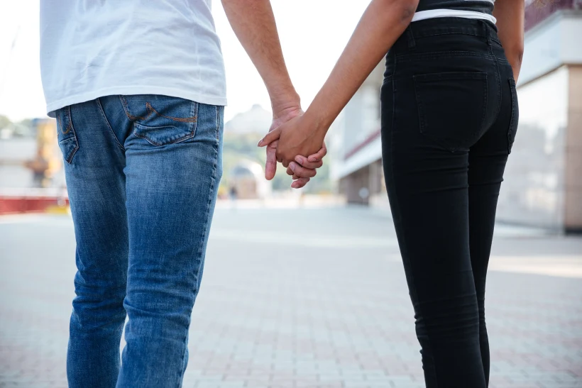 Back View Of Couple Standing And Holding Hands Outdoors