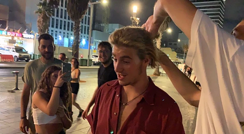 עמית שטח מסתפר בטיילת ת״א.