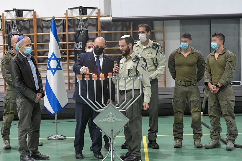 ראש הממשלה נפתלי בנט מדליק חנוכיה עם לוחמי מג''ב