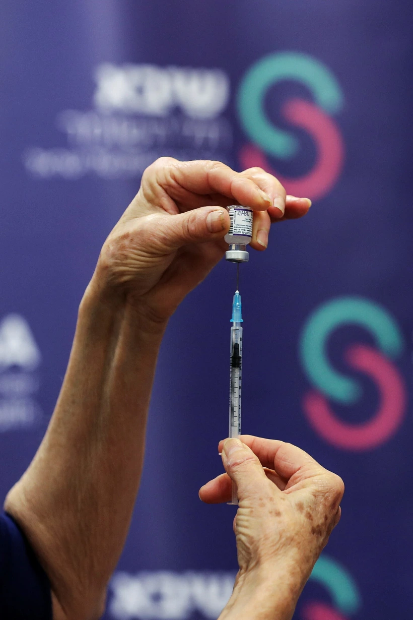 אחות מכינה מנת חיסון רביעי בבית החולים שיבא תל השומר