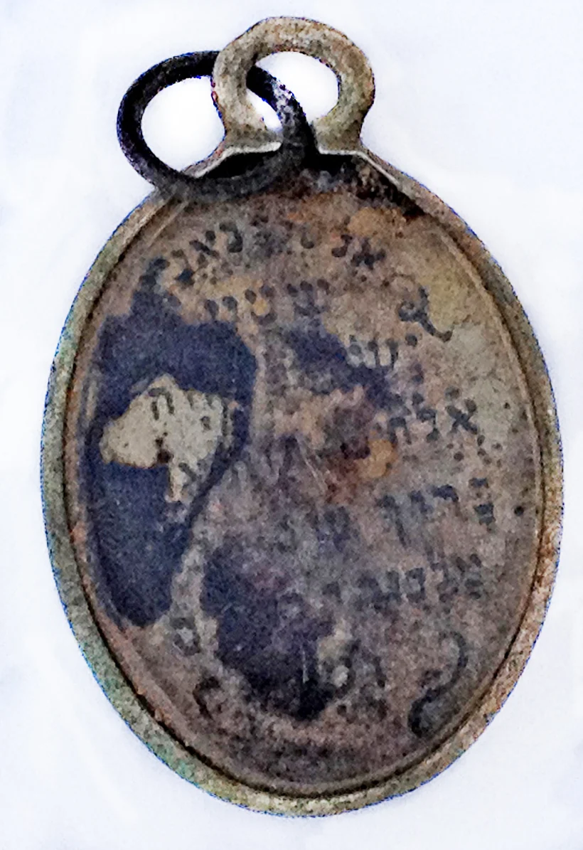 תליון ''שמע ישראל'' שהתגלה בצריף התפשטות הנשים במחנה ההשמדה סוביבור