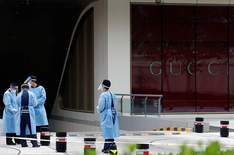 עובדים בחליפות מגן ליד קניון סגור בעקבות התפרצות הקורונה בבייג'ינג